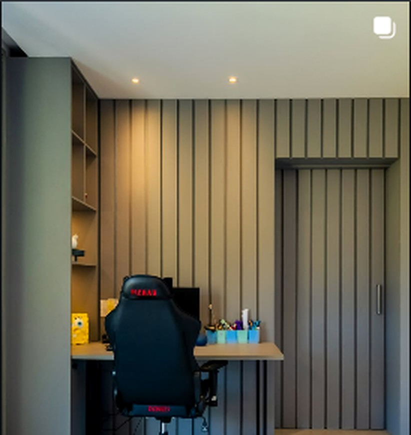 Home office com marcenaria escura e estação de trabalho