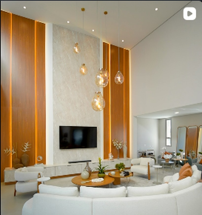 Sala de estar com pé-direito alto, madeira e iluminação decorativa